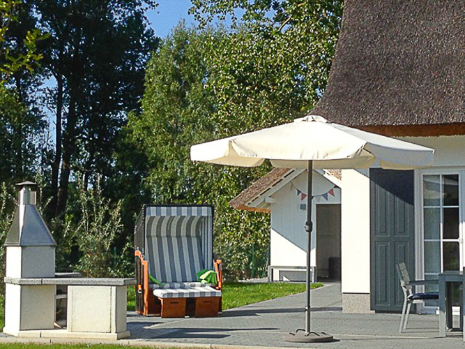 Südterrasse von Haus Albatros mit stationärem Grill und Strandkorb
